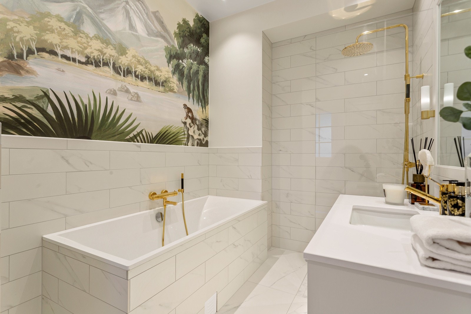 Dekorert veggfelt over badekar, samt garnityr og blandebatterier i messing setter prikken over i-en. Galleribilde