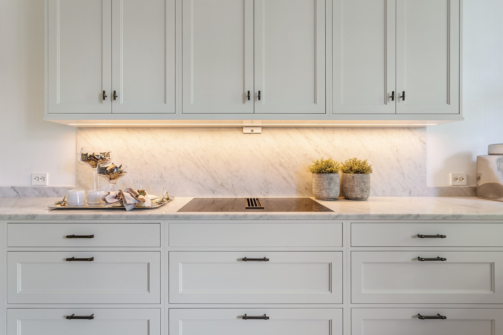 Benkeplater i 30 mm tykk marmor med underlimt kum i rustfritt stål, og integrerte hvitevarer fra Miele bidrar til å forsterke det luksuriøse preget. Det er også lagt marmorplater på vegg mellom over- og underskap. Galleribilde