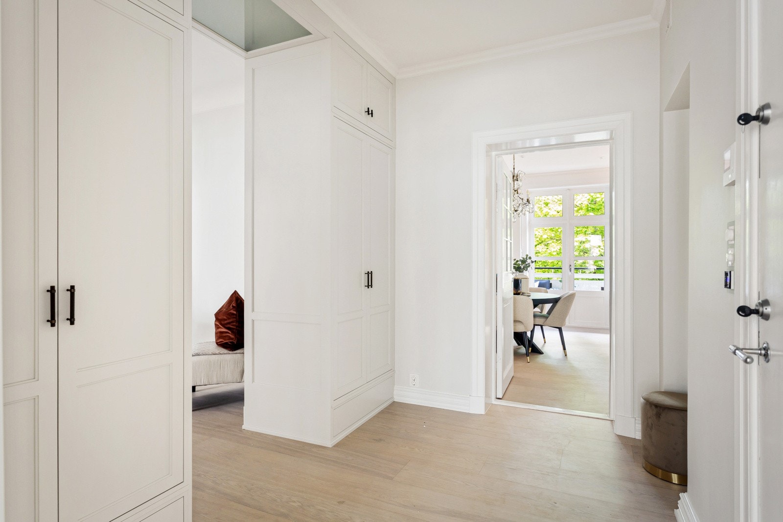 Ytterdøren er produsert på Jømna Brug og er spesiallaget med håndmalte ornamenter etter den originale døren. Døren fører inn i en lys og åpen entré/hall. Spesialtilpassede garderober fra Terna Snekkeri tar seg av bekledningen. Galleribilde