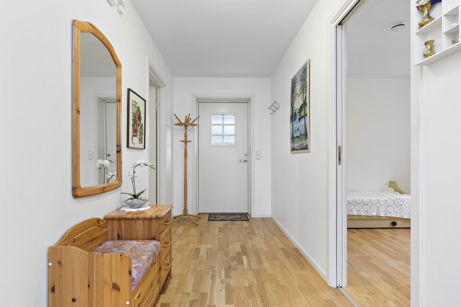 Entréen er lys, med god plass til knagger og oppbevaringsmøbel til yttertøy og sko. Galleribilde