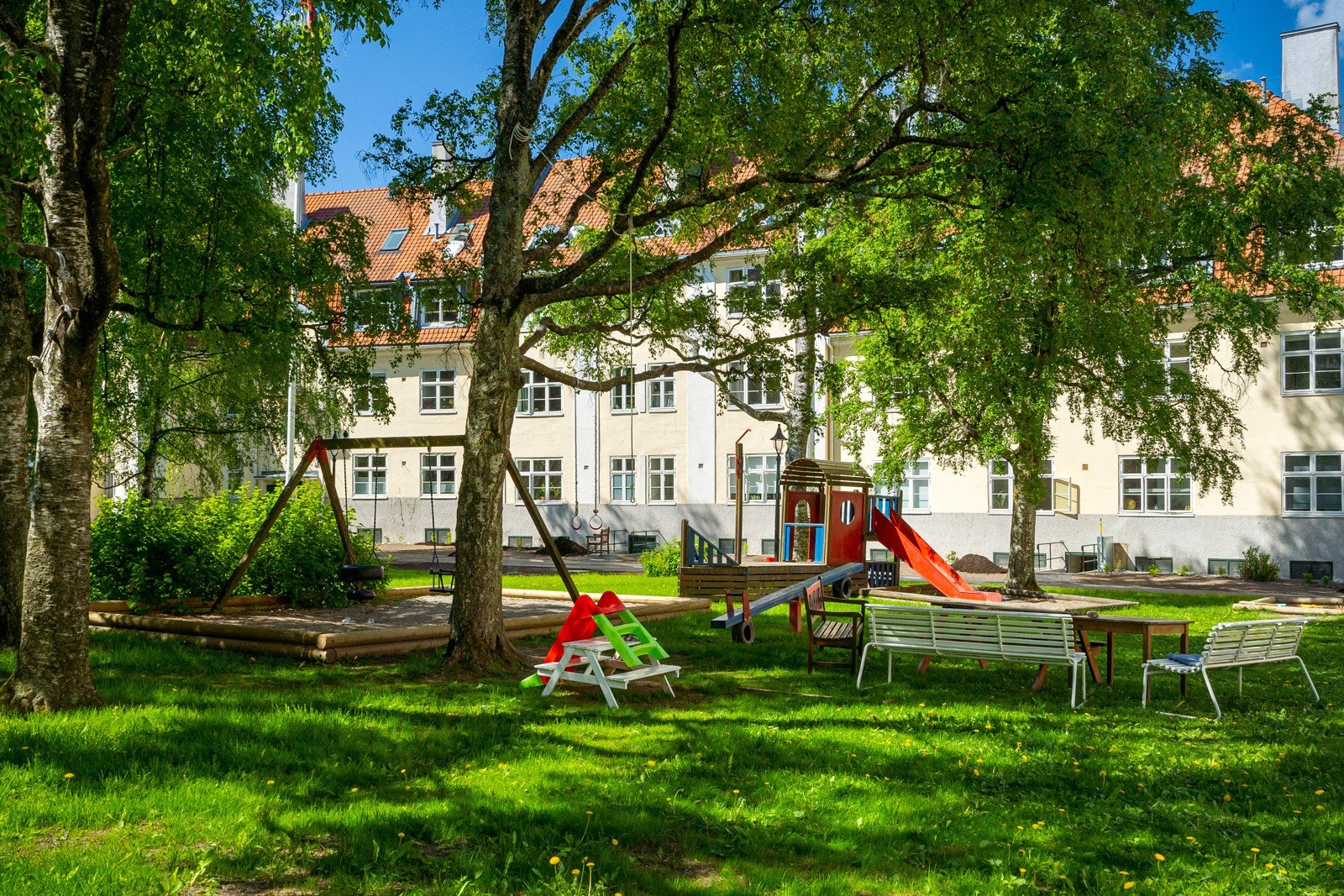 Utenfor leiligheten er det hyggelige bakgård med lekeplass og sittegrupper. Galleribilde