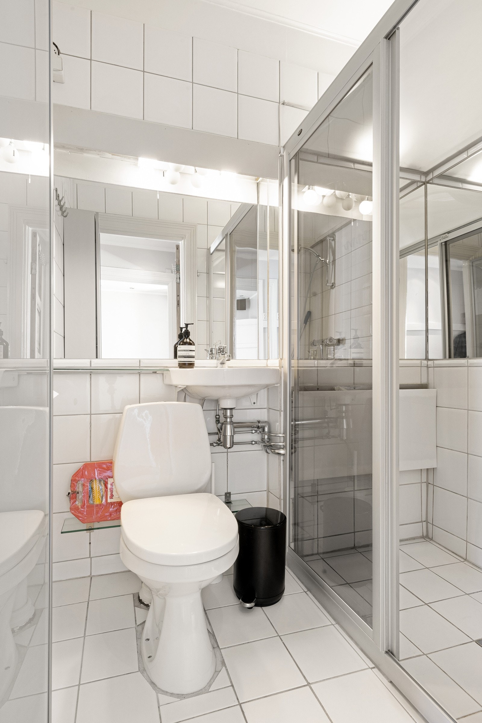 Baderom i hovedetasjen innredet med toalett, servant og dusj i hjørne. Galleribilde