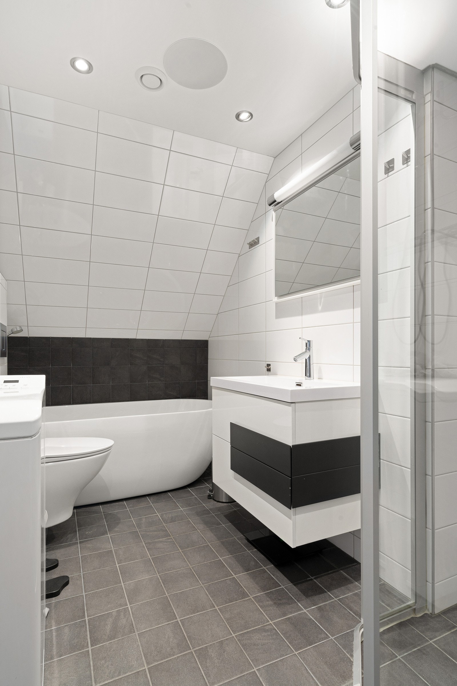 Badet i loftetasjen er innredet med taoeltt, servantinnredning, Tylö steamdusj, frittstående badekar og opplegg for vaskemaskin. Galleribilde