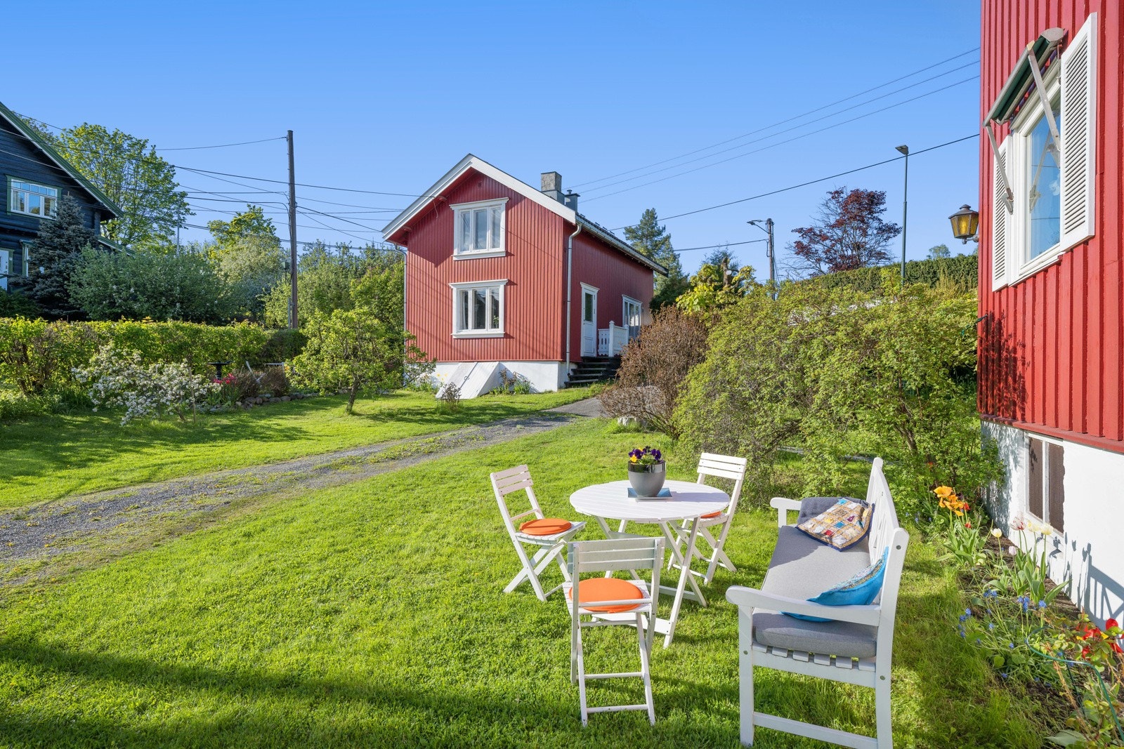 Opparbeidet tomt med gruset adkomstparti, gressplen, trær, prydbusker og blomsterbed Galleribilde