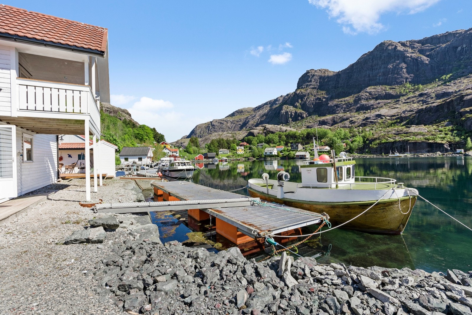 Eiendommen har et godt opparbeidet kaianlegg med flytebrygge som følger med salget - Det følger i tillegg med halvpart av flytebrygge som ligger ved naboeiendom (lengst bort i bildet) Galleribilde