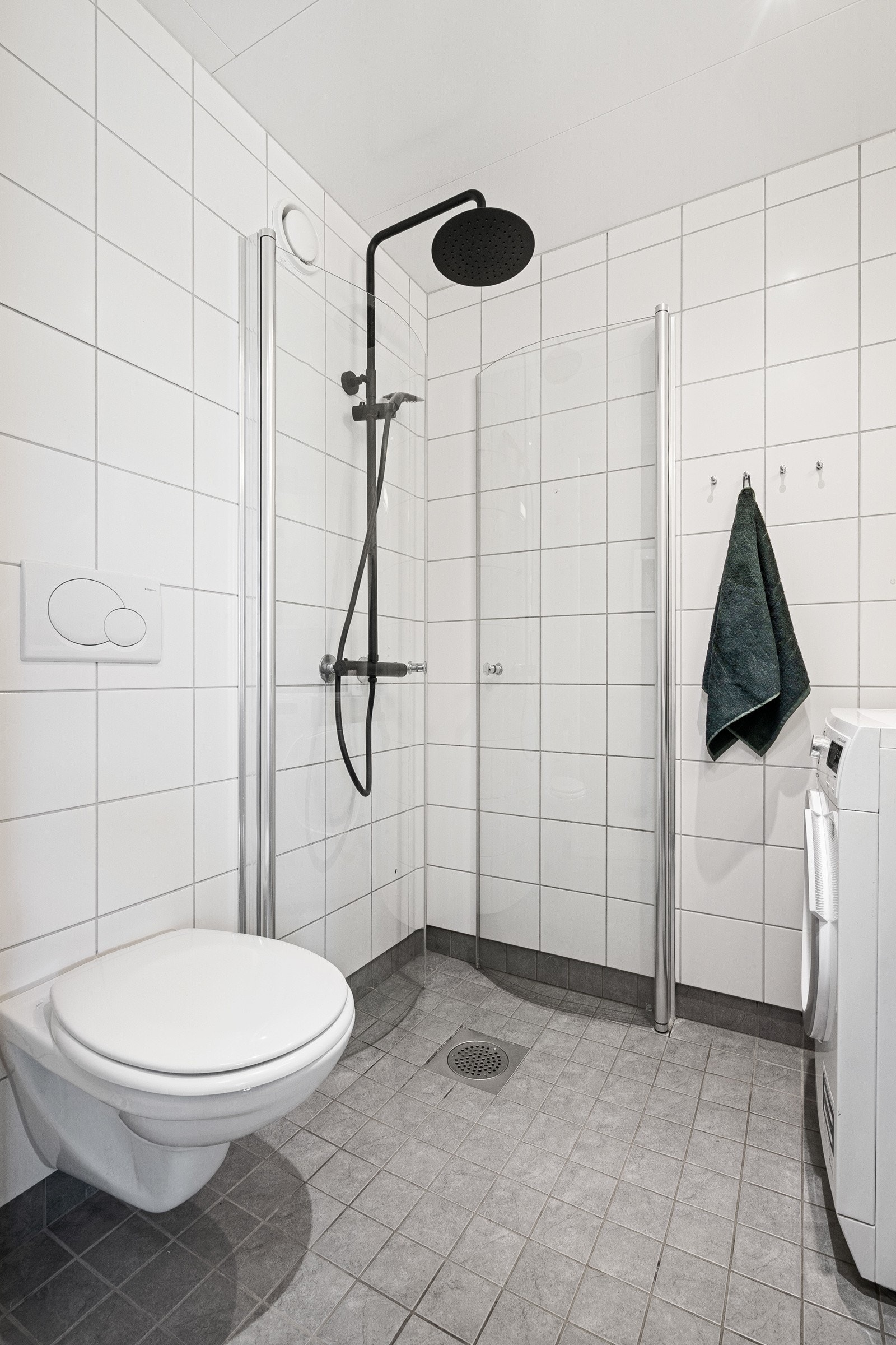 Dusjplass med innfellbare dusjdører, samt regnfallsdusj og hånddusj. Veggmontert WC. Galleribilde