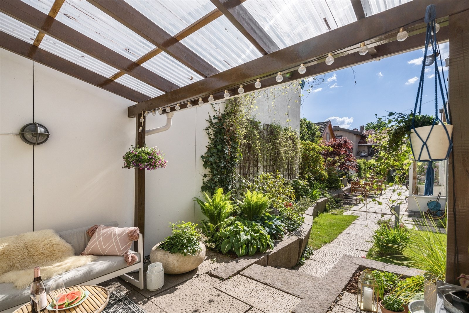 Uteplassen har pergola med gjennomsiktige bølgeplater som slipper lyset gjennom. Galleribilde
