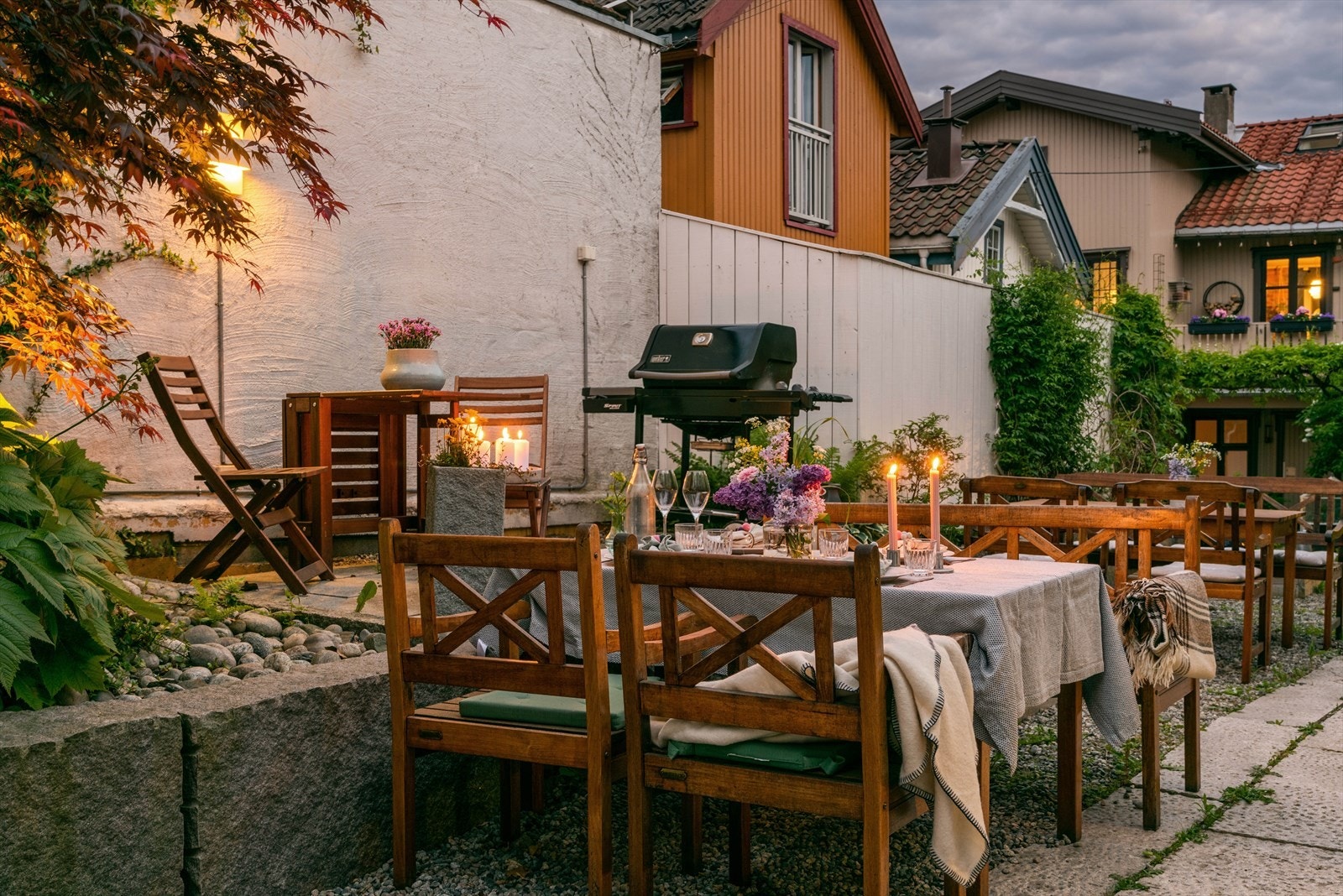 Bakgården har felles grillplass med sittegrupper. En landskapsarkitekt har designet felles bedd og grillplass. Galleribilde