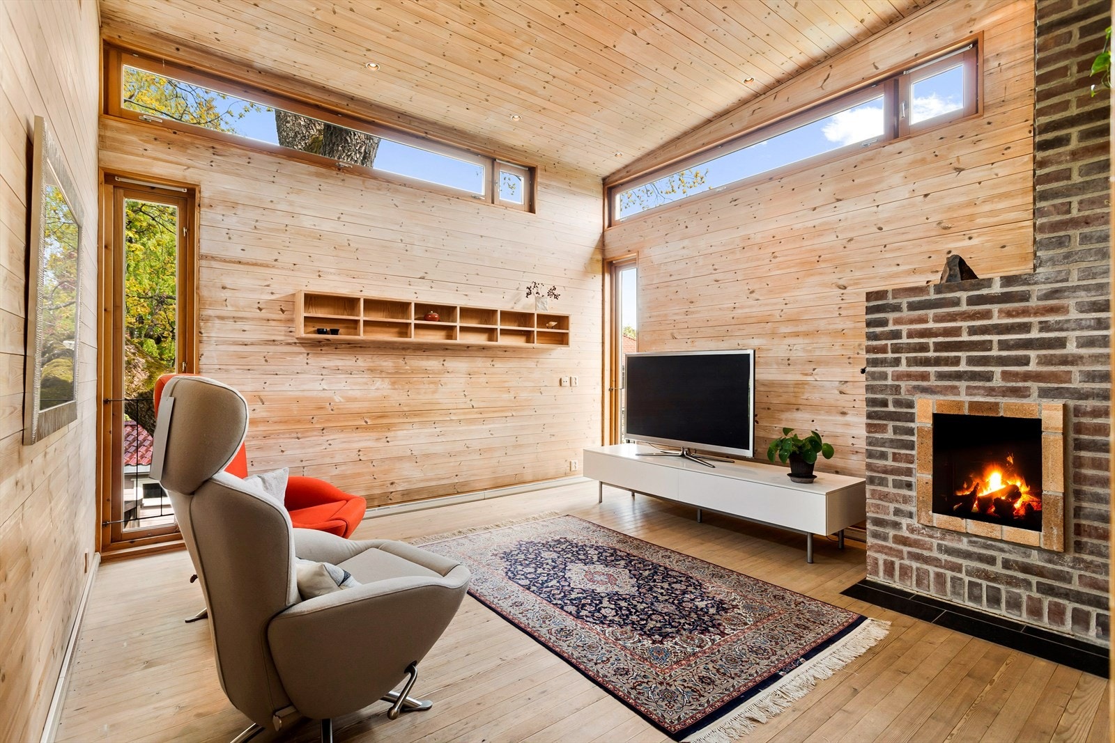 Romslig medierom med teglstein-peis. Galleribilde