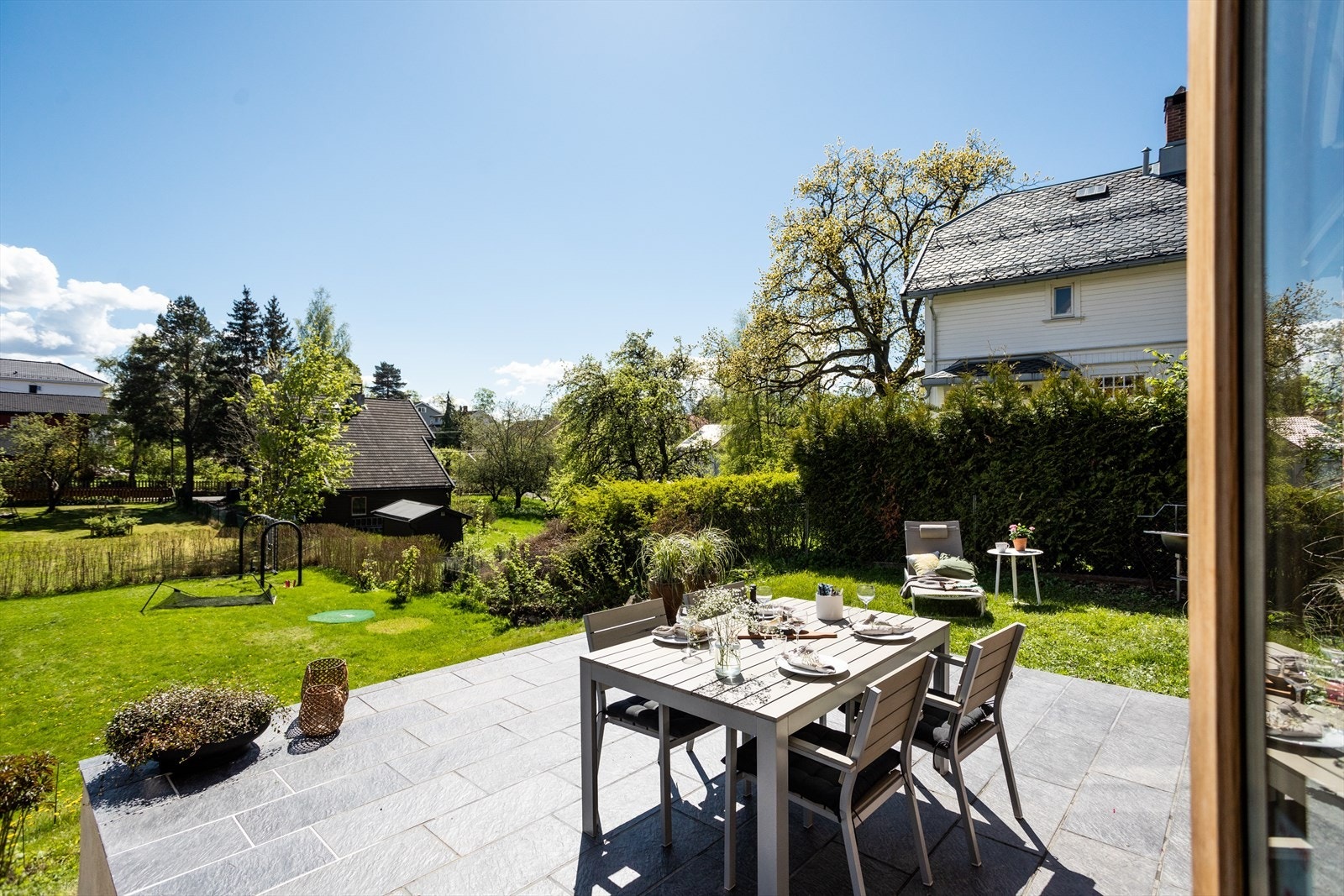 Fra spisestuen er det utgang til en stor og solrik flisbelagt platting. Galleribilde