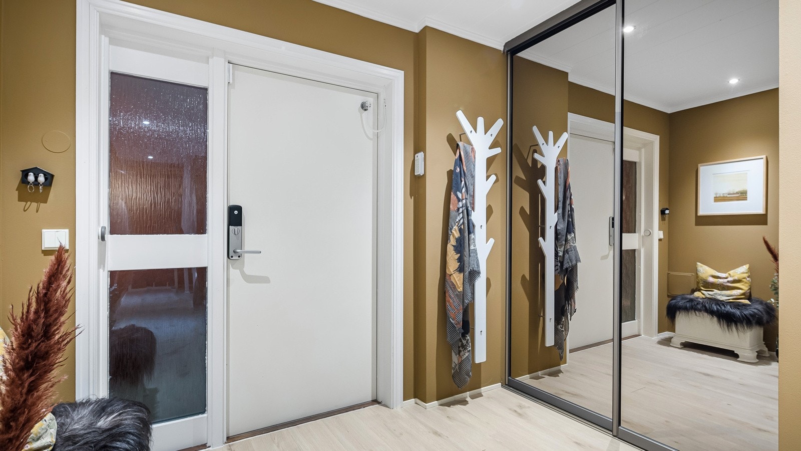 . Det innbydende inngangspartiet har vegger i en delikat fargetone og på gulvet er det lagt laminatgulv Galleribilde