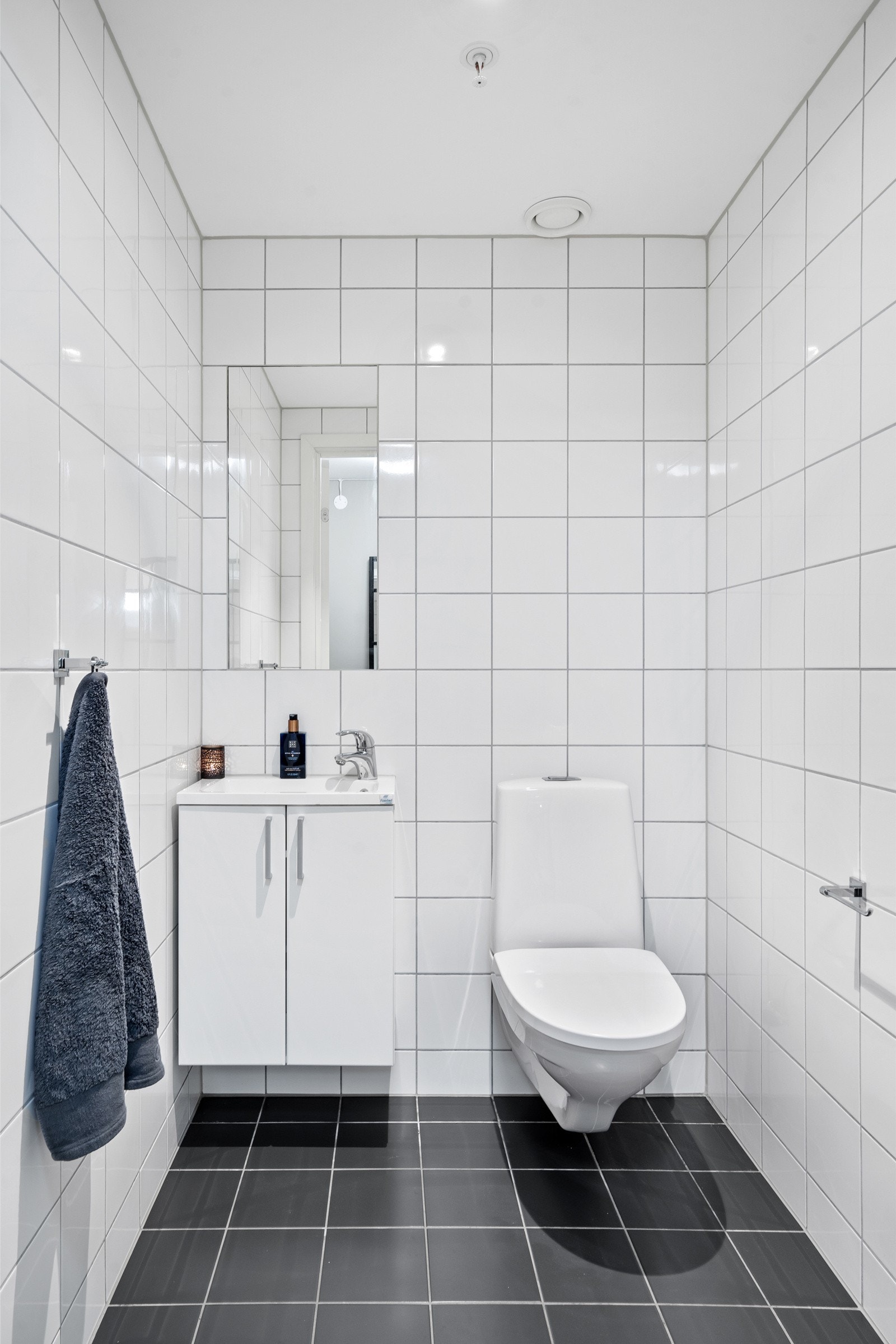 Separat toalettrom som inneholder servant med underskap, speil og vegghengt toalett med dimbare downlights i himling. Galleribilde