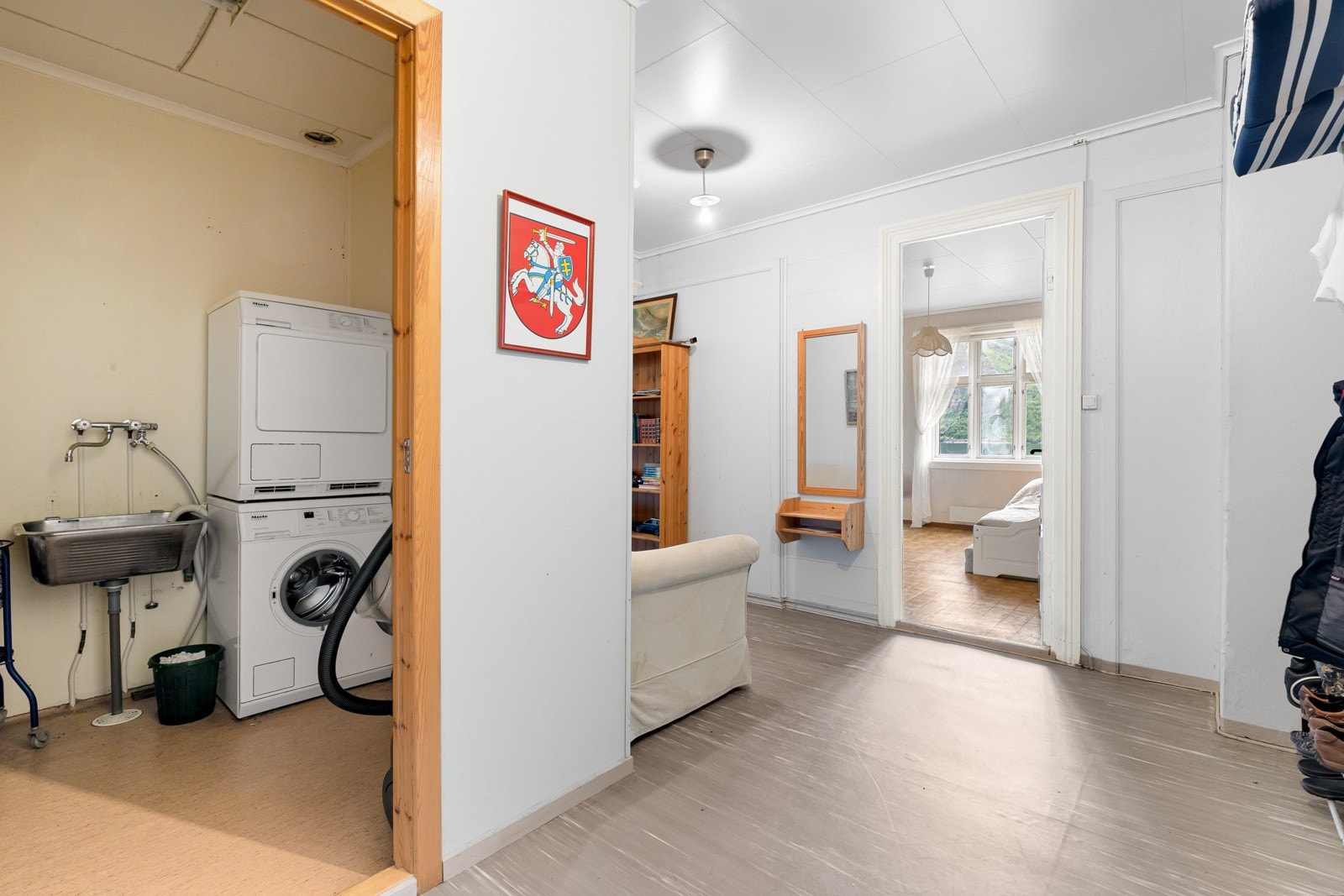 Vaskerom med belegg på golv, og malte plater og beleggoppbrett på vegger. Det er også skyllekar og opplegg for vaskemaskin. Galleribilde