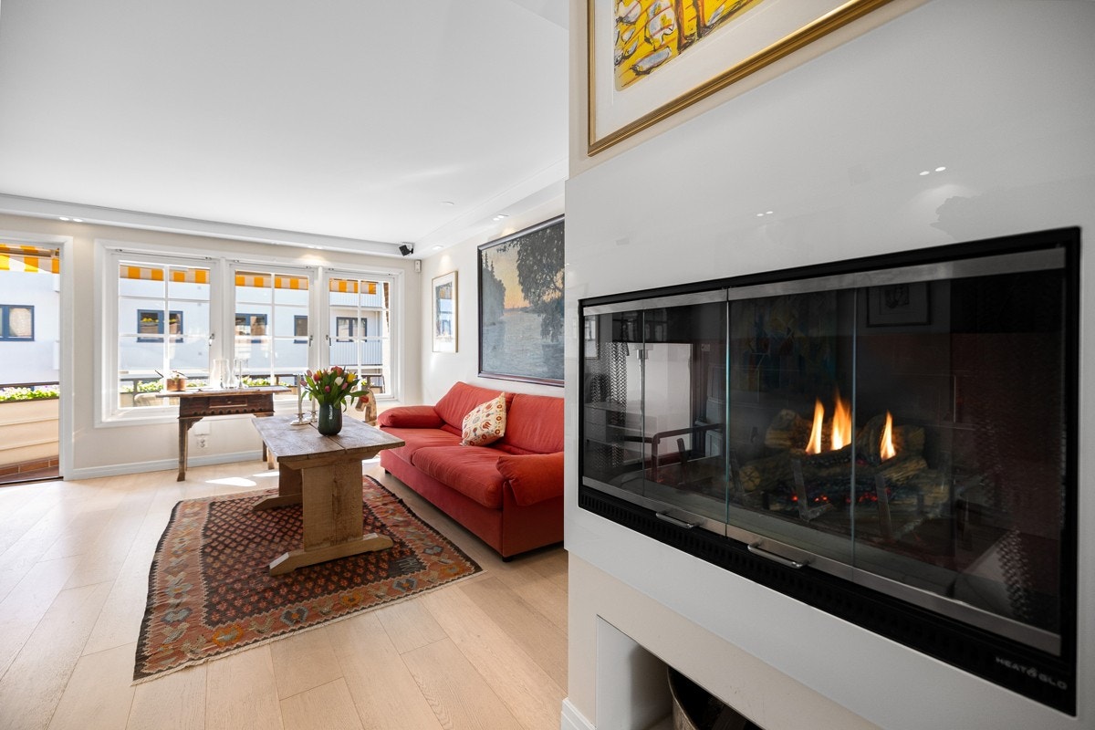 Den lekre peisen fungerer som en naturlig romdeler og gir deilig varme i den kaldere årstiden. Galleribilde