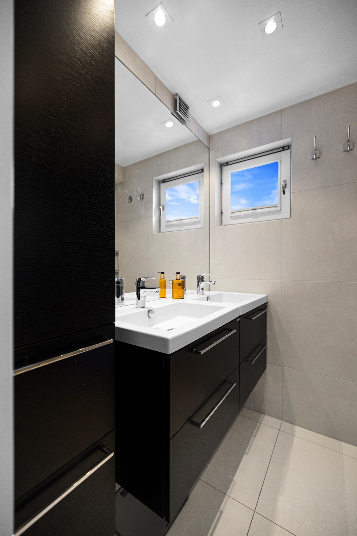 Baderomsinnredningen har sorte, matte fronter og heldekkende dobbelservant. Galleribilde