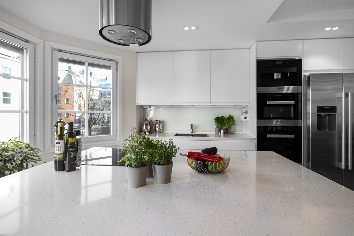 Videre er kjøkkenet utstyrt med integrert induksjonstopp, mikrobølgeovn, kaffemaskin, oppvaskmaskin, vinskap og side-by-side kjøleskap. Galleribilde