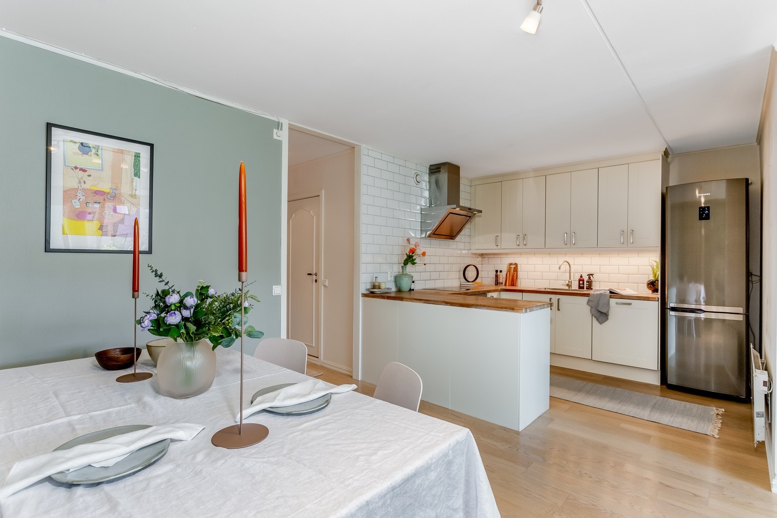 Pent kjøkken med slette fronter og heltre benkeplate Galleribilde