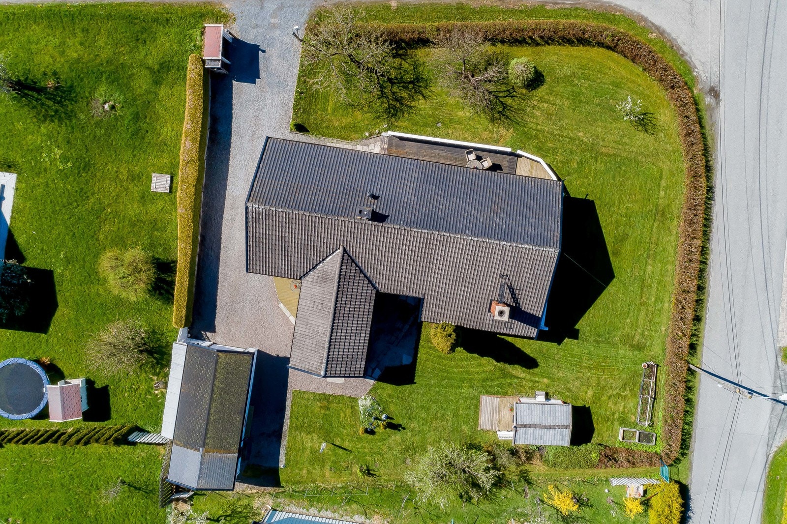 Tomten er lett skrånende, pent opparbeidet med gruslagt gårdsplass. Galleribilde