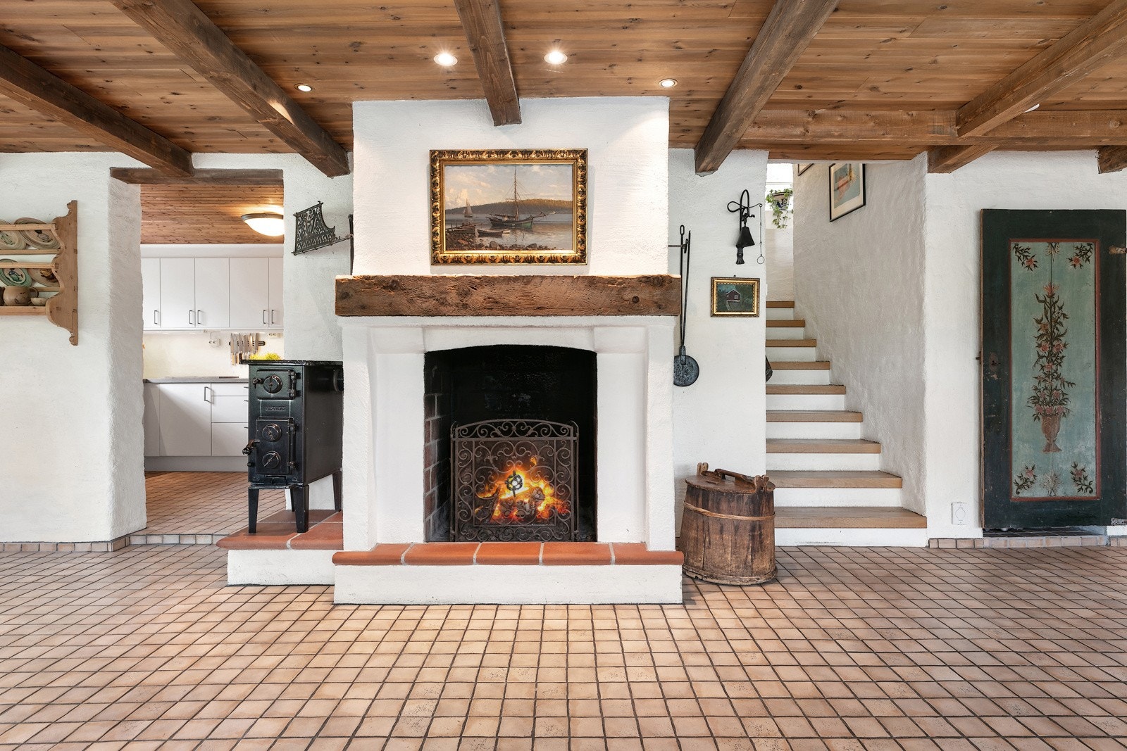 Åpen peis, inngang til kjøkken og trapp opp til stue og 1 etasje Galleribilde