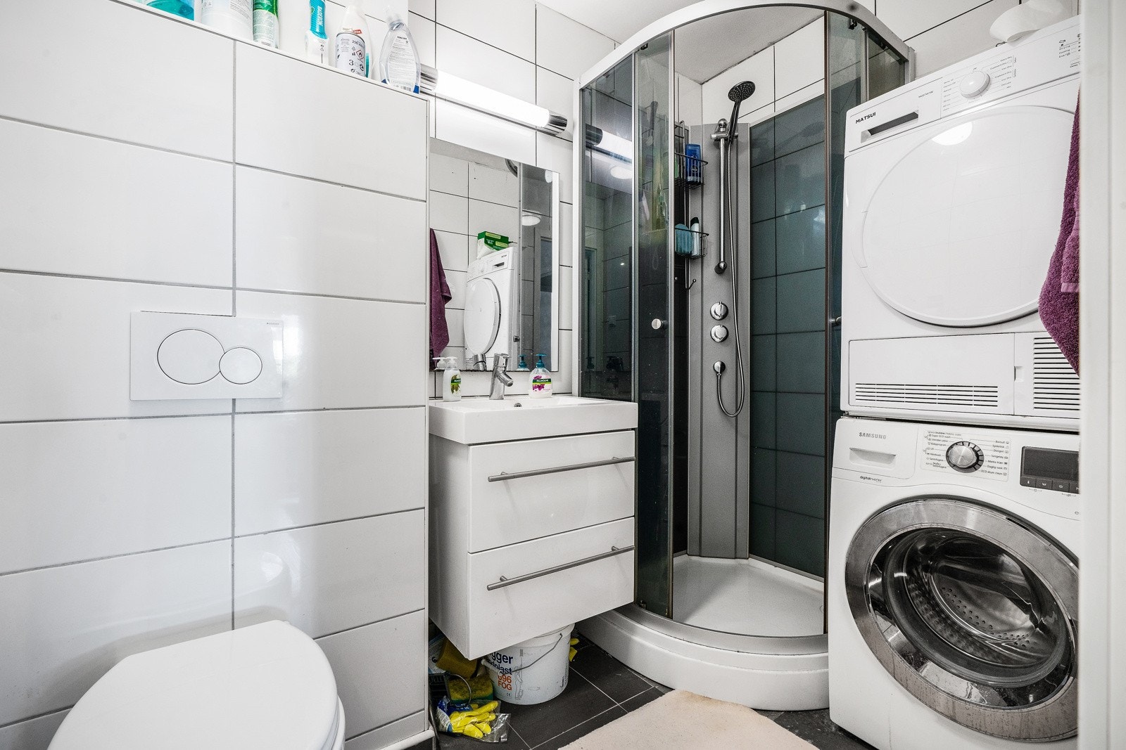 Flislagt bad med toalett, dusjkabinett, servant og opplegg for vaskemaskin Galleribilde