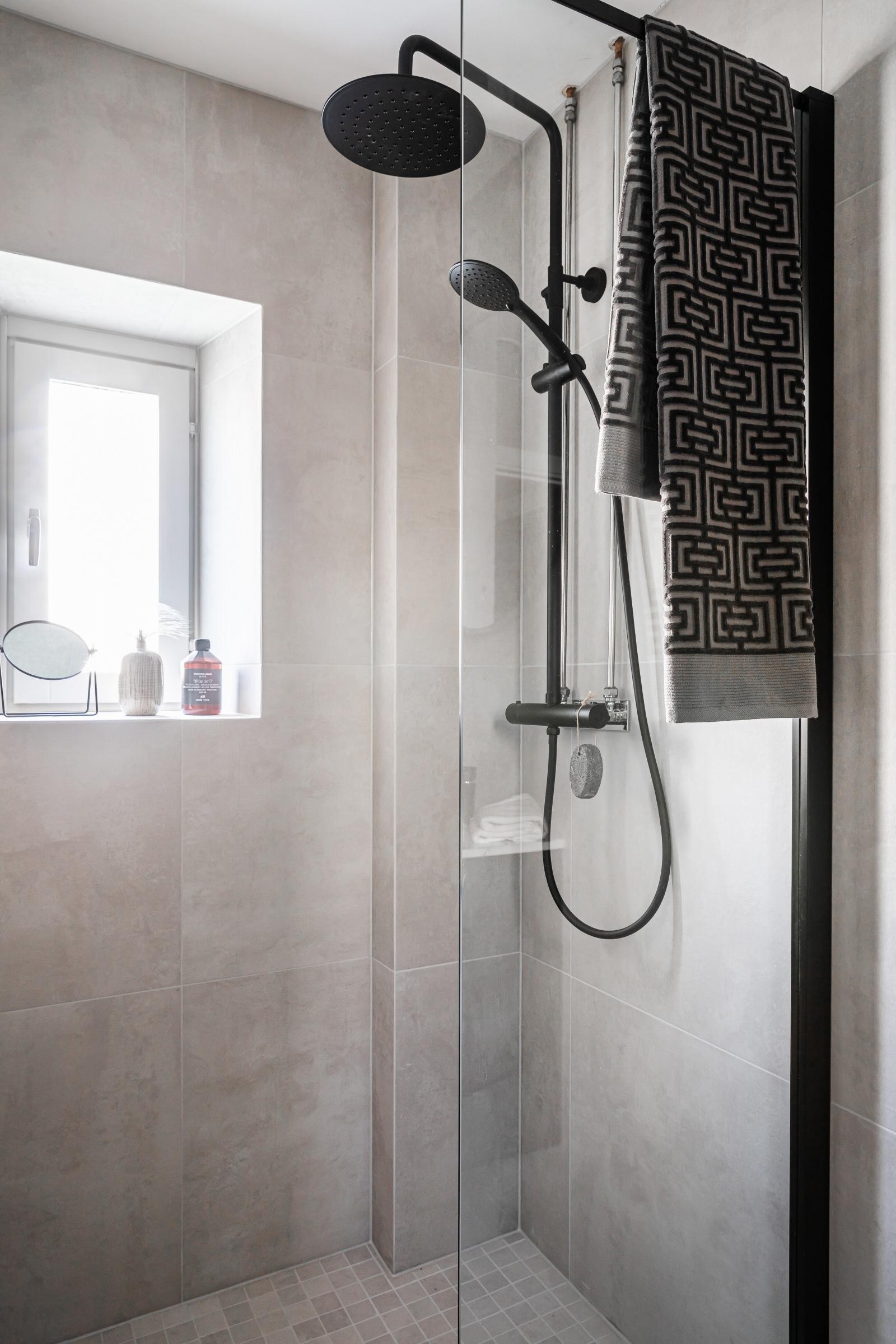 Badet har lekker regnfallsdusj og hånddusj i sort utførelse, samt glassvegg. Galleribilde