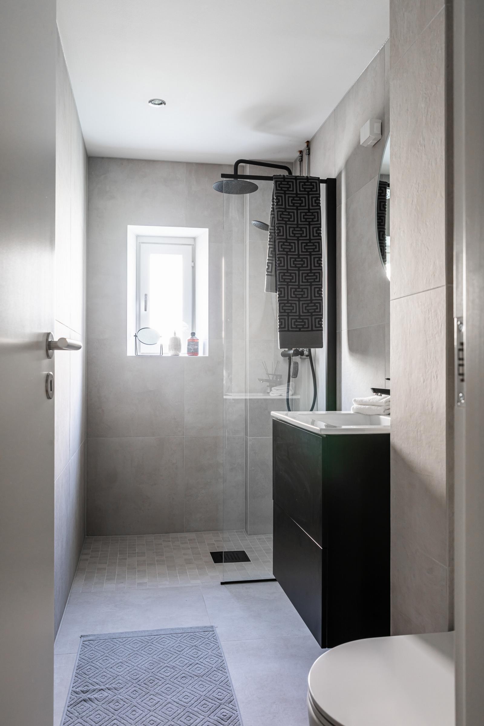 Badet har sort moderne servantinnredning, vegghengt toalett og mulighet for tilkobling av vaskemaskin. Galleribilde