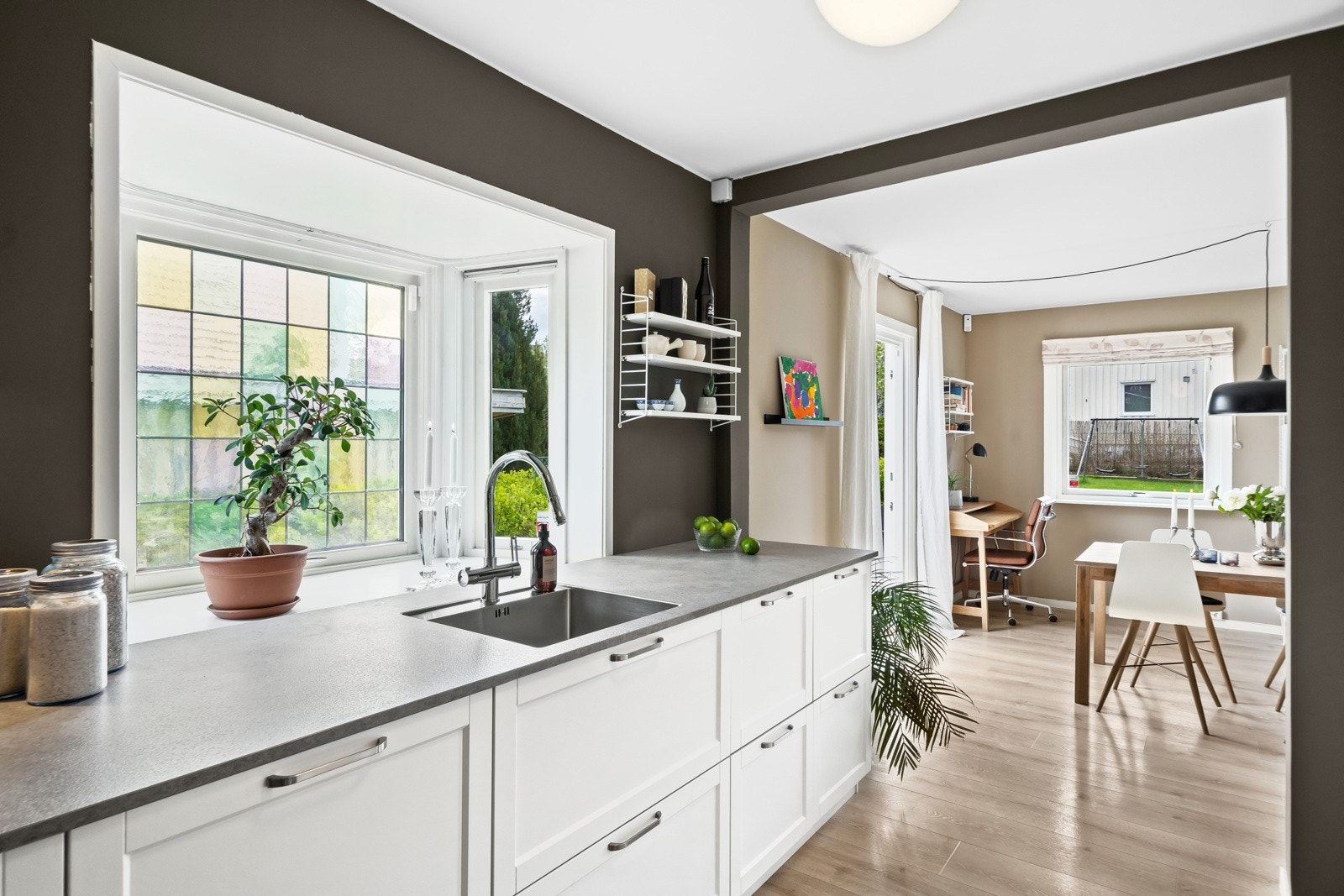 Kvik-innredningen fra 2017 har hvite, profilerte fronter og laminert benkeplate med nedfelt oppvaskkum Galleribilde