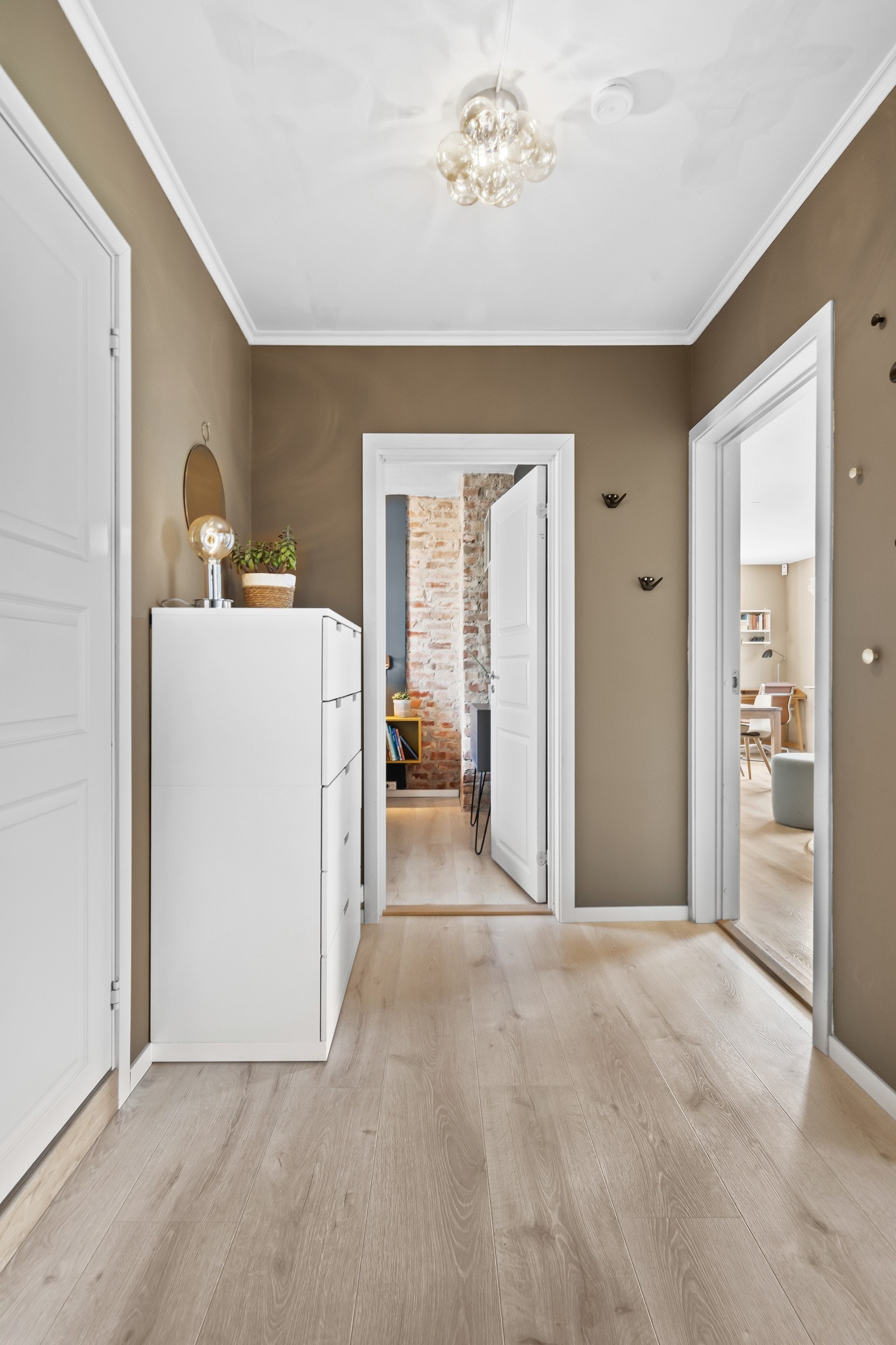 Entreen er innbydende med 1-stavs laminatgulv og veggflater malt i en mørk, trendy jordtone Galleribilde