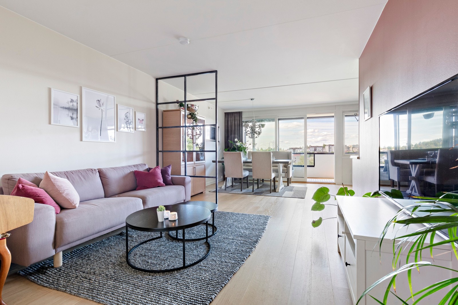 Store vindusflater mot balkongen og en fin fargepalett sørger for en lett og behagelig atmosfære i stuen. Galleribilde