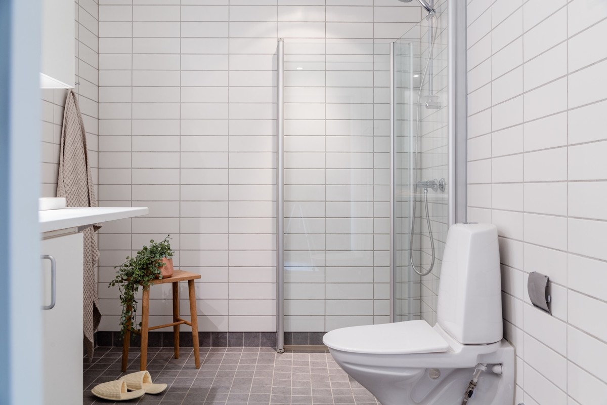 Badet har lyse og nøytrale fliser samt gulvvarme. Videre er det vegghengt klosett, dusjnisje med innfellbare glassdører og en praktisk servantinnrending med god lagringsplass. Galleribilde