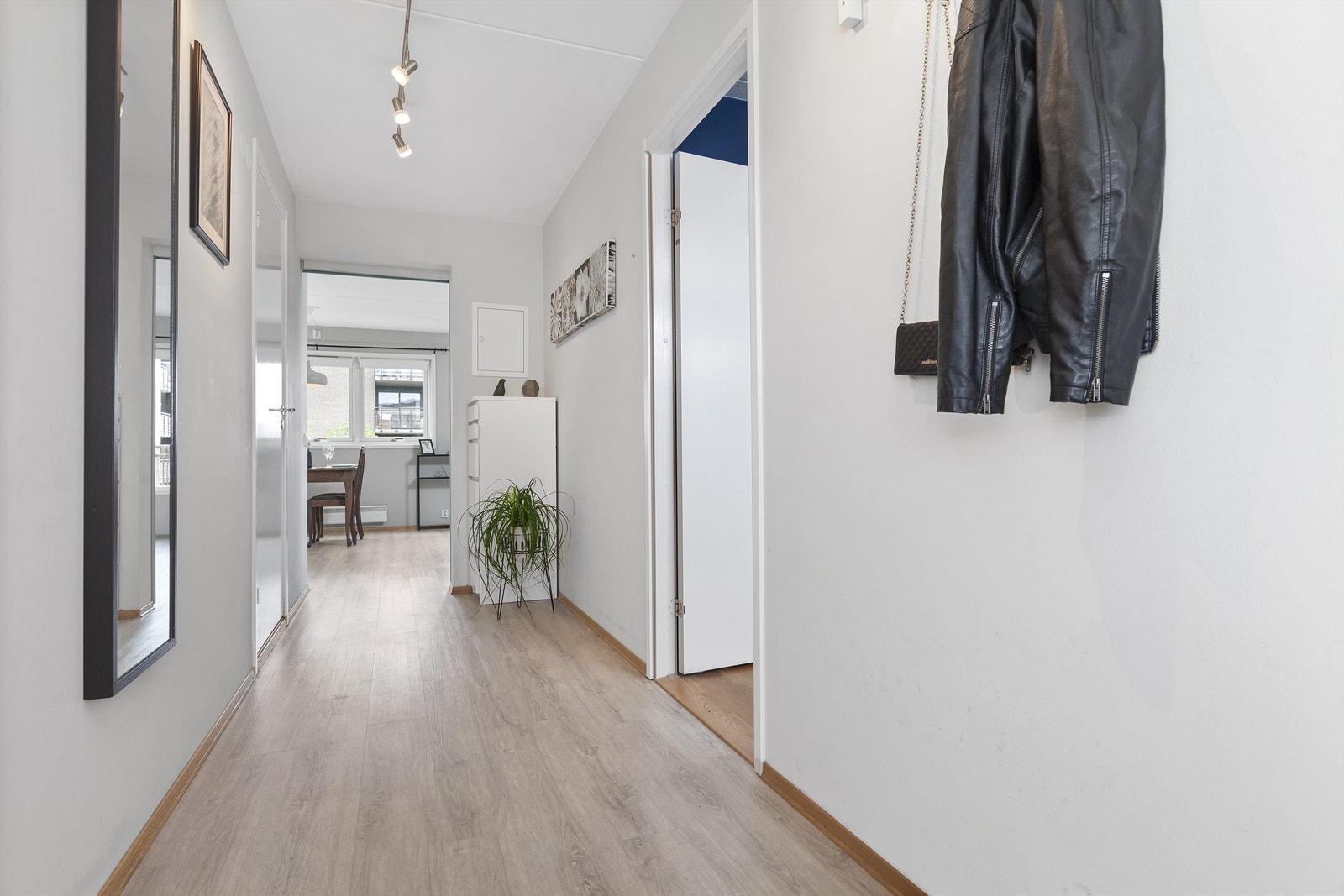 Innbydende og romslig entré/gang med god plass til oppbevaring av sko- og yttertøy. Adkomst til begge soverom, badeværelse og stue/kjøkken. Galleribilde
