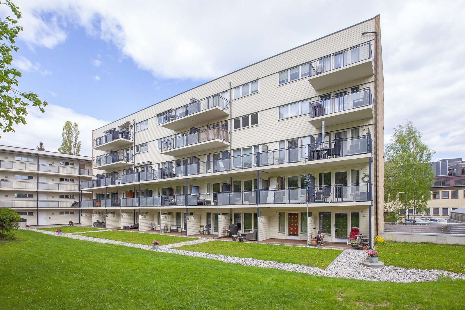 Balkongen vender inn mot pent opparbeidet gårdsrom. Galleribilde