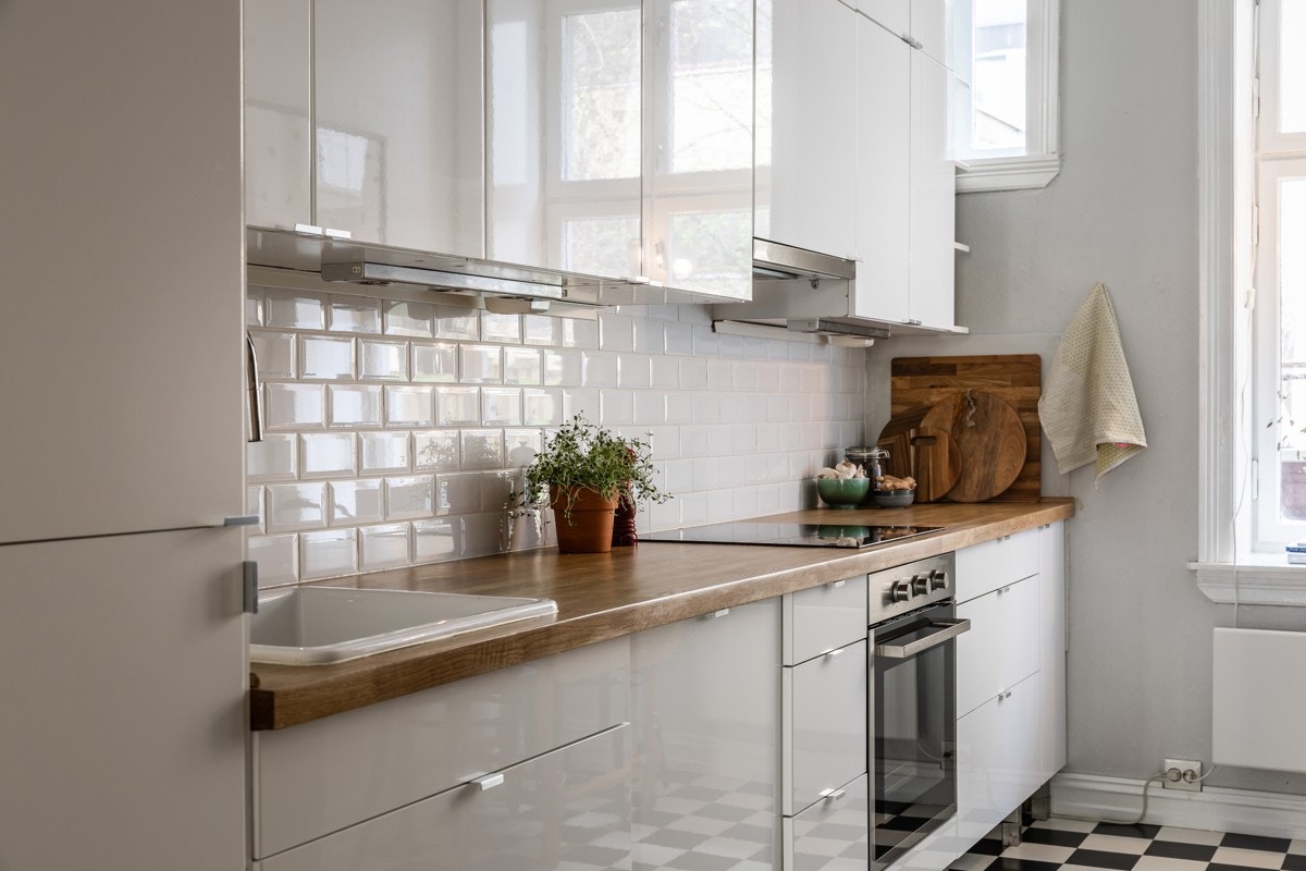 Kjøkkeninnredningen består av hvite høyglans fronter, heltre benkeplate, servant, ventilator, integrert komfyr, platetopp, kjøleskap, fryser og oppvaskmaskin. Galleribilde