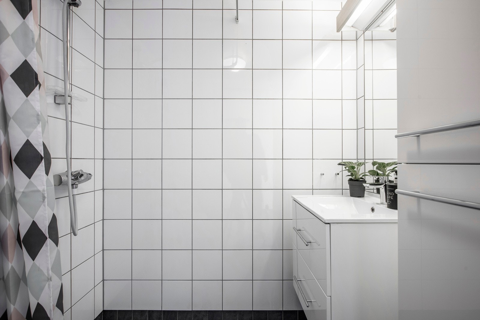 Pent bad med varmekabler i gulv og flislagte overflater. Leietaker benytter i dag vaskemaskin i fellesvaskeri i kjeller. Galleribilde