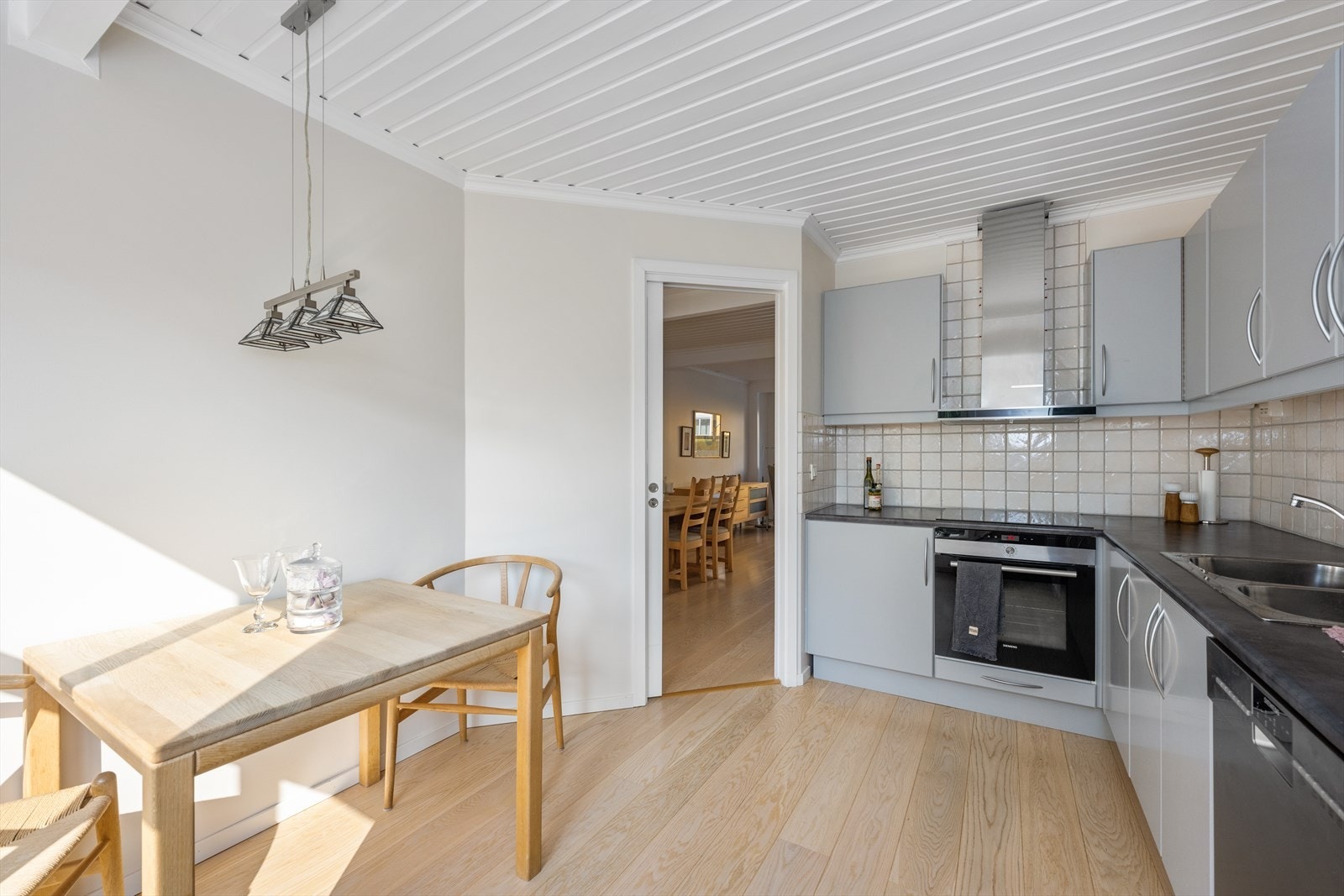 Over benken er det flislagt og belysing. Kjøkkenet er utstyrt med induksjonstopp, avtrekksvifte, komfyr. kjøleskap og oppvaskmaskin. Galleribilde