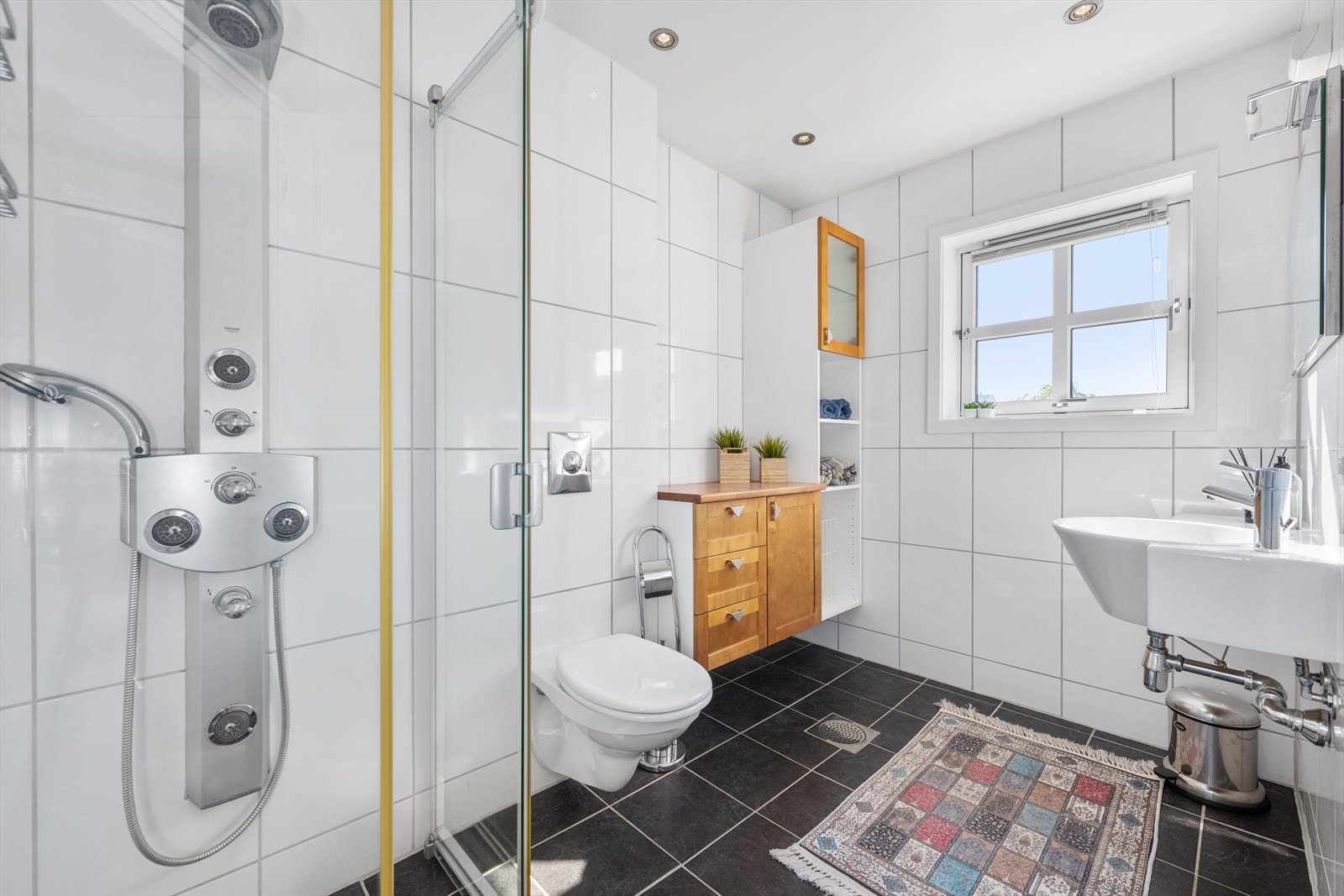 Pent flislagt baderom med downlights i taket og varmekabler i gulvet. Galleribilde