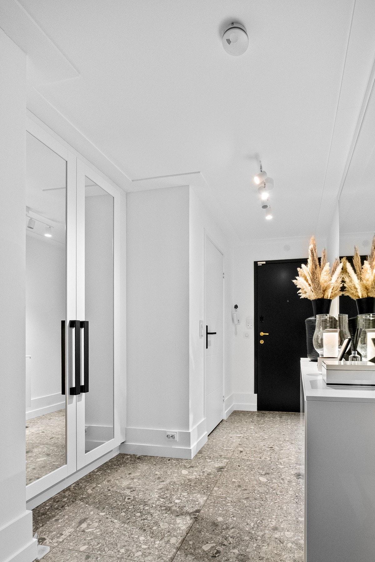 Det lyse inngangspartiet har vegger malt i tidløs farge og et romslig garderobeskap med innebygd innredning. Galleribilde