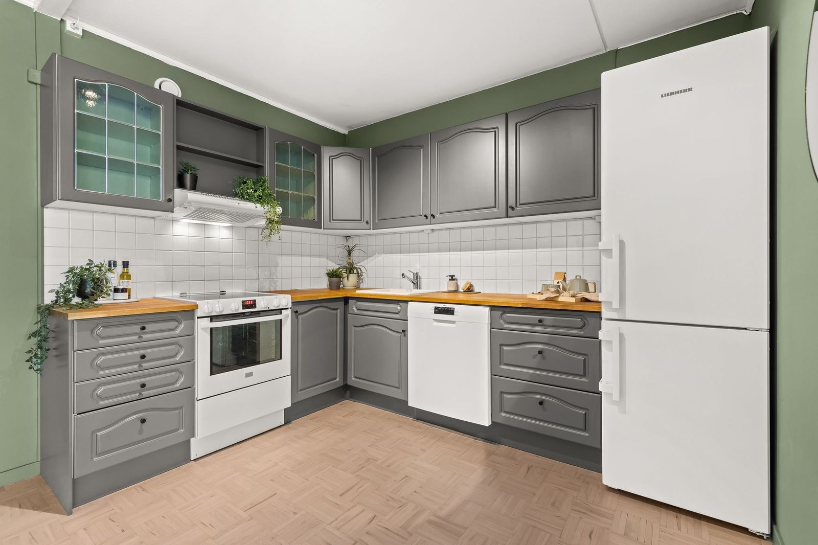 Kjøkken med profilerte fonter, flisbelagt backsplash og heltre benkeplate. Galleribilde