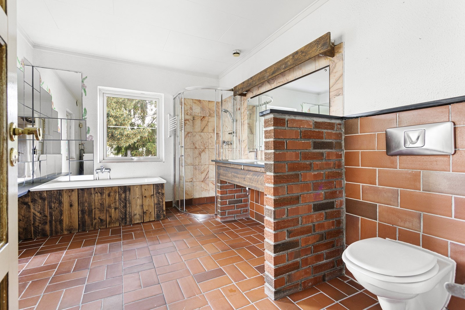 Badet i 2. etg. har fliser på gulv, samt flislagte og pussede vegger. Innredningen består av en dusjsone, et badekar og et vegghengttoalett. Galleribilde