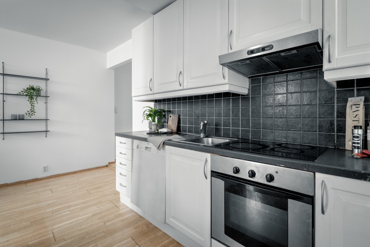 Kjøkkenet består av kjøkkeninnredning med hvite fronter og laminert benkeplate Galleribilde