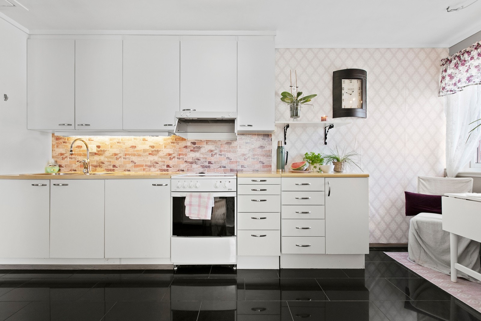 Kjøkkenet er pent og koselig med takhøy innredning med hvite, slette fronter. Galleribilde