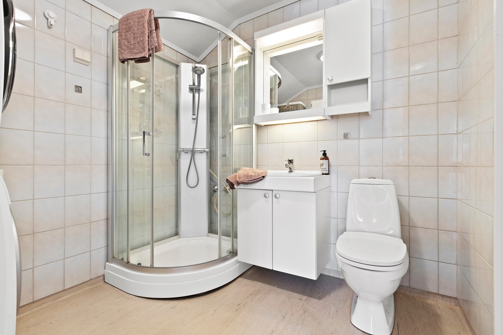 Badet er holdt i lyse toner - med fliser på veggene, belegg på gulv og gulvvarme. Galleribilde