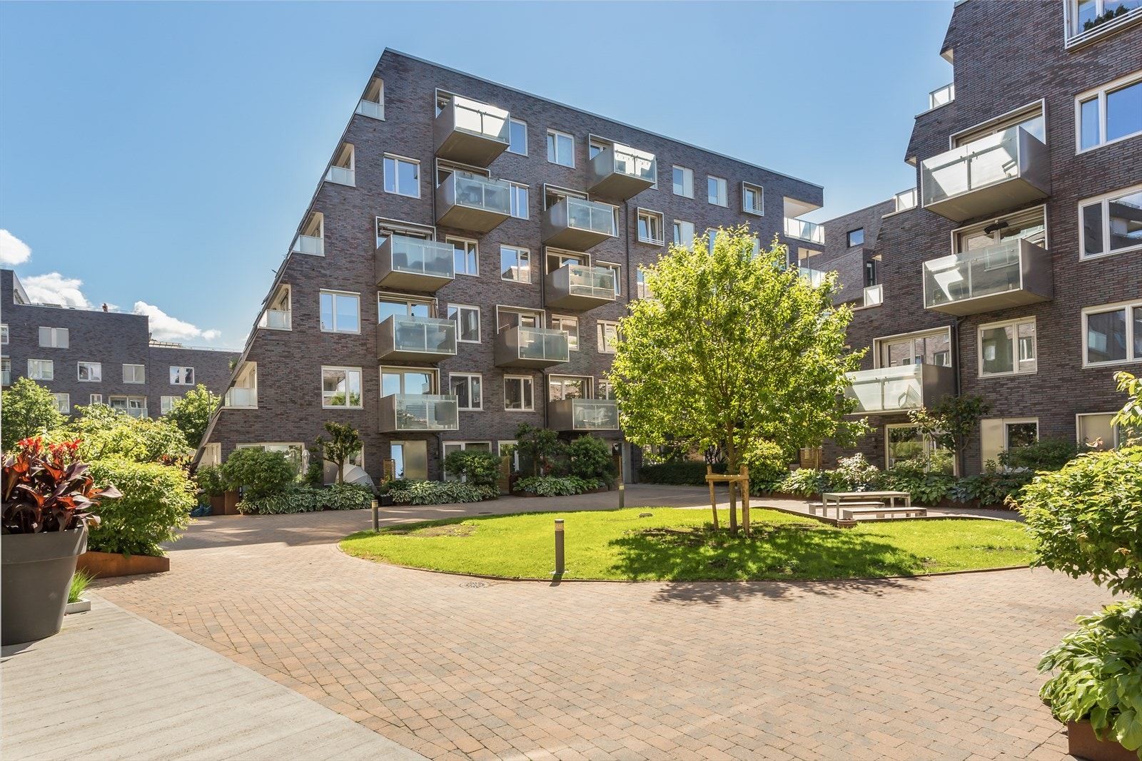 Hyggelig område rett utenfor leiligheten med sittegrupper og grøntområder. Galleribilde