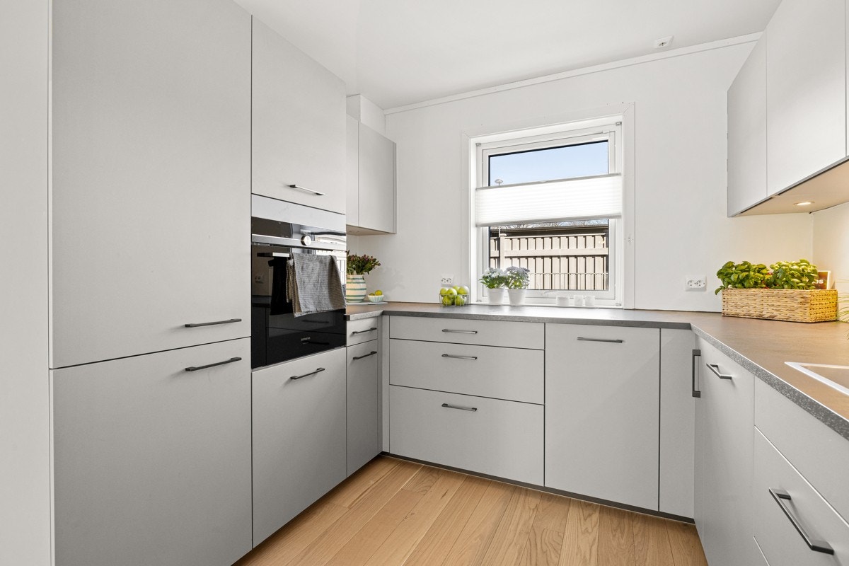 Kjøkkenet er innredet med glatte fronter, laminat benkeplate, ventilator, komfyrvakt, waterguard, oppvaskkum og integrerte hvitevarer. Galleribilde