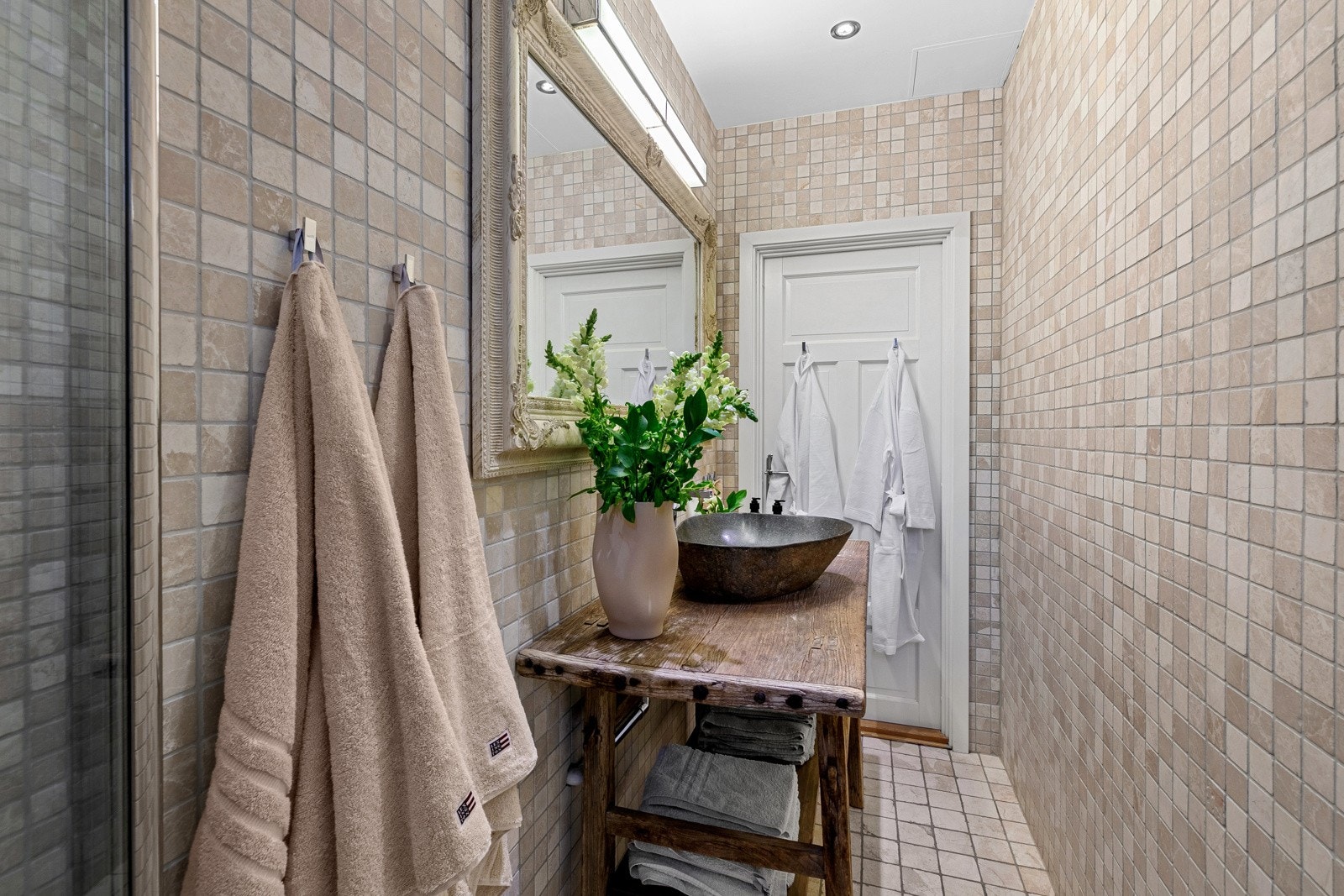 Gulvstående servantinnredning i tre med utenpåliggende steinvask og ett-greps armatur i krom. Selger har dokumentasjon på utført arbeid. Badet har fått tilstandsgrad 1 av takstmann. Galleribilde