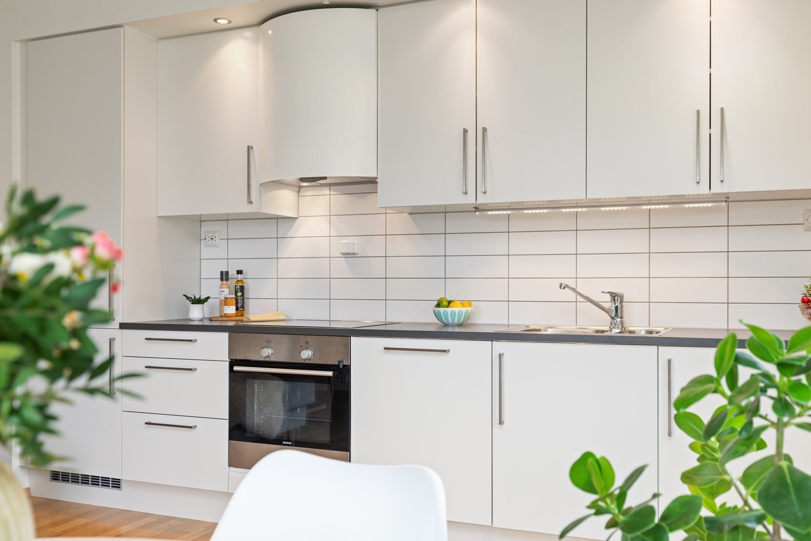 Kjøkkenet fra HTH med takhøye skap, integrerte hvitevarer fra Siemens og downlights i himling. Galleribilde