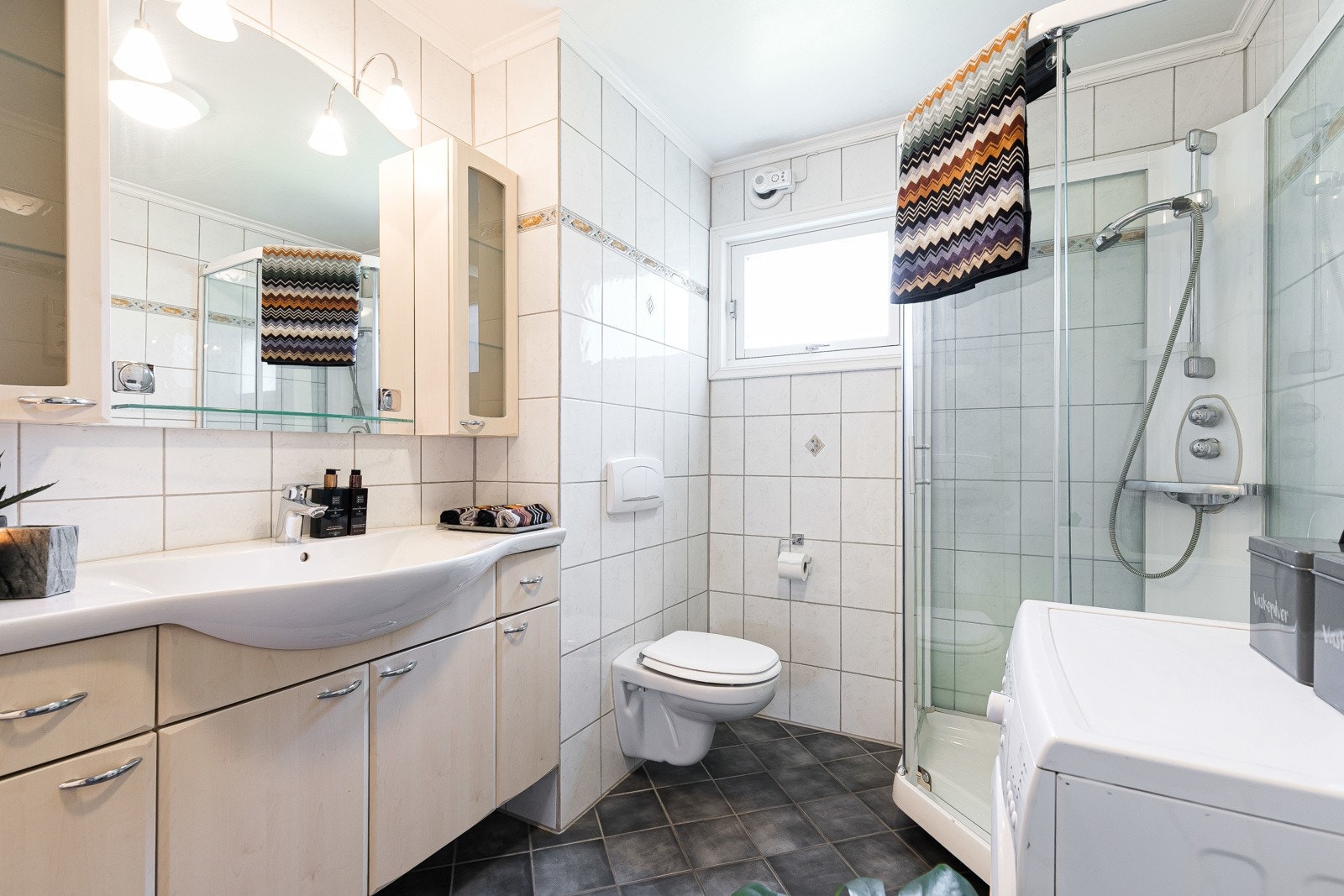 Den romslige innredningen har underskap og skuffer med bjerkefolierte, slette fronter, heldekkende servant, overskap og speilhylle med belysning. Galleribilde