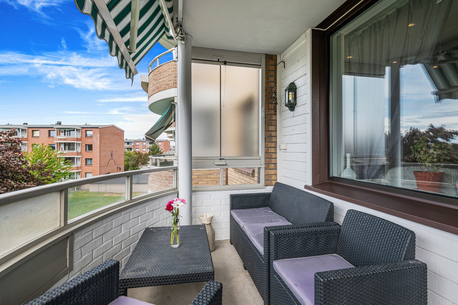 Balkongen har buet, tett rekkverk, med glass på toppen, og det er frostet, skjermende vindu på den ene siden. Galleribilde