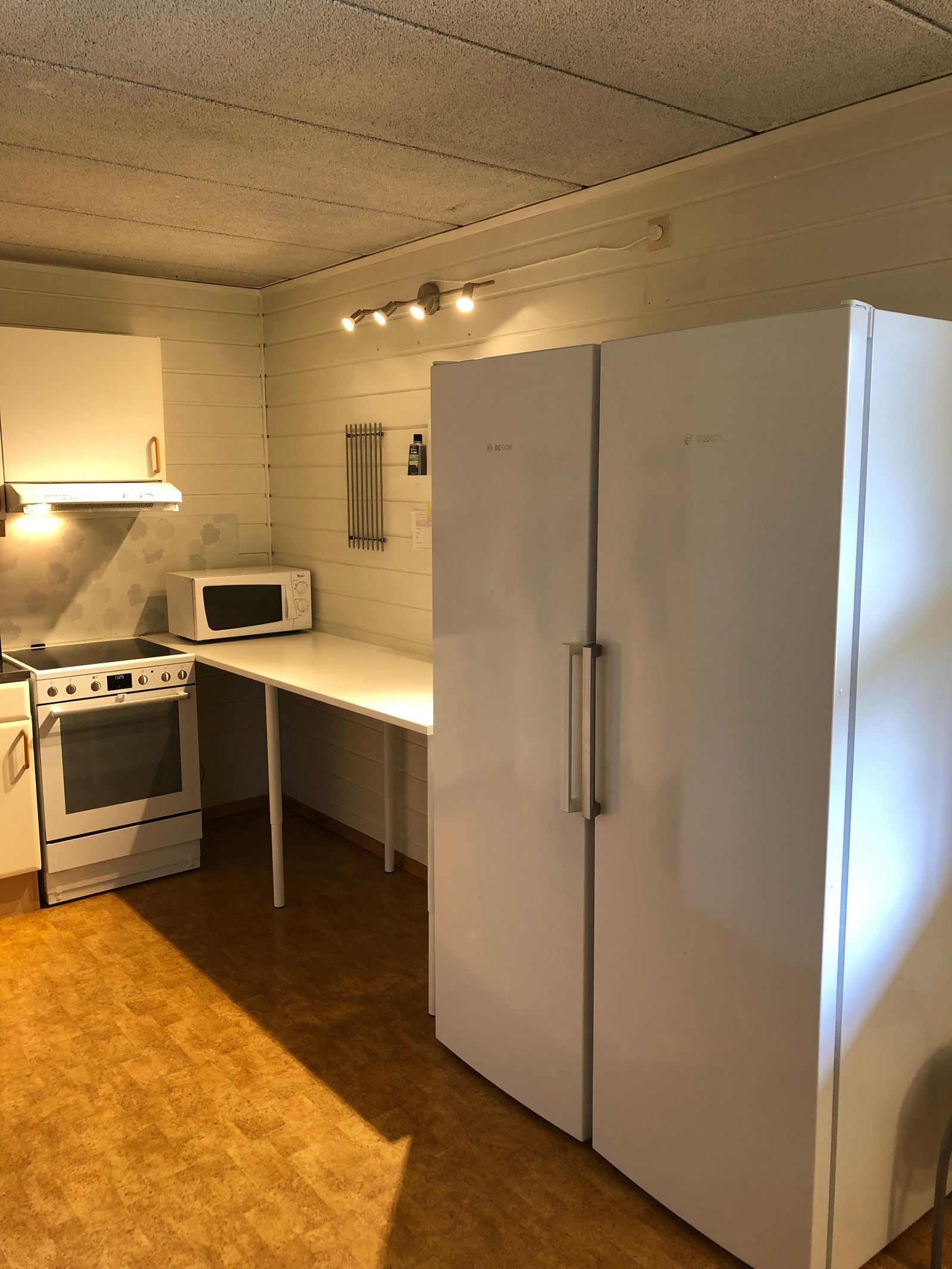 Stort kjøleskap og fryseskap på felles kjøkken. Galleribilde