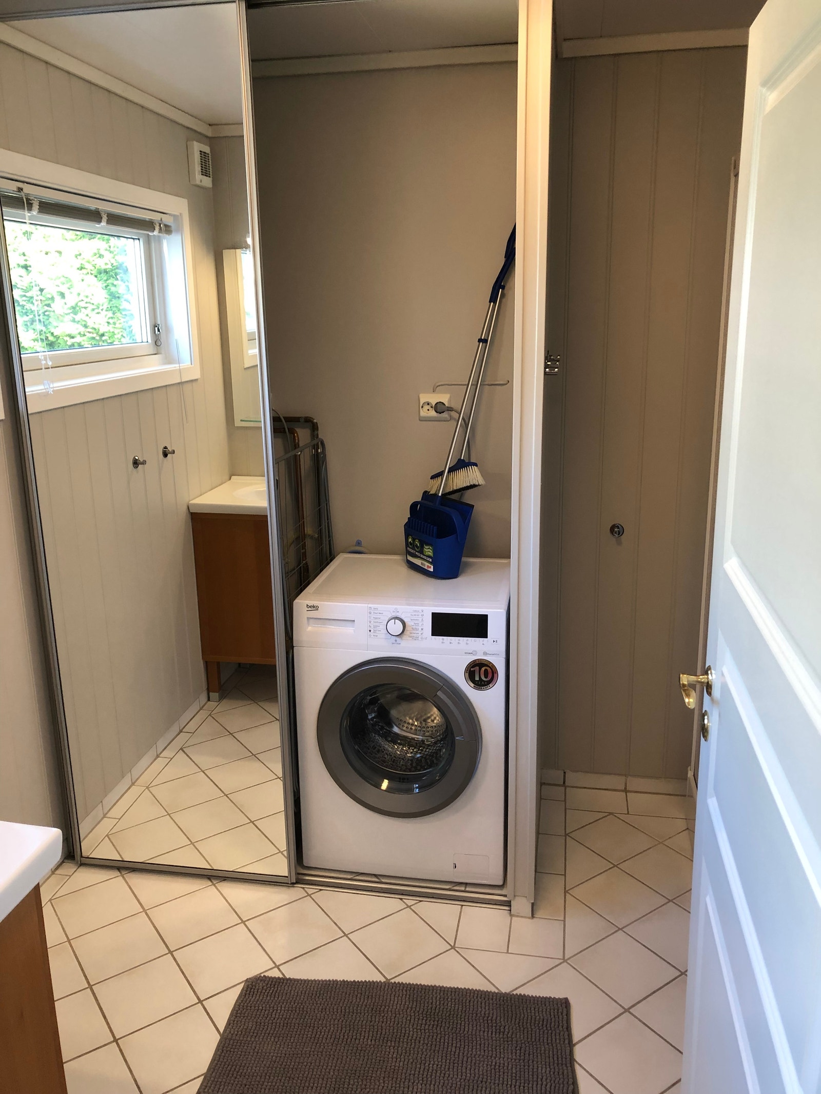 Bad Vaskemaskin + varmtvannstank (+tørketrommel, ikke med i bilde) bak skap Galleribilde